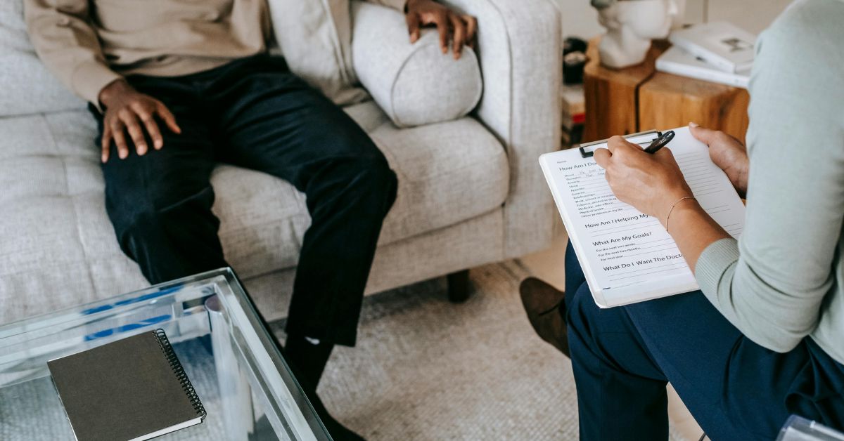 Therapist taking notes during a counseling session.